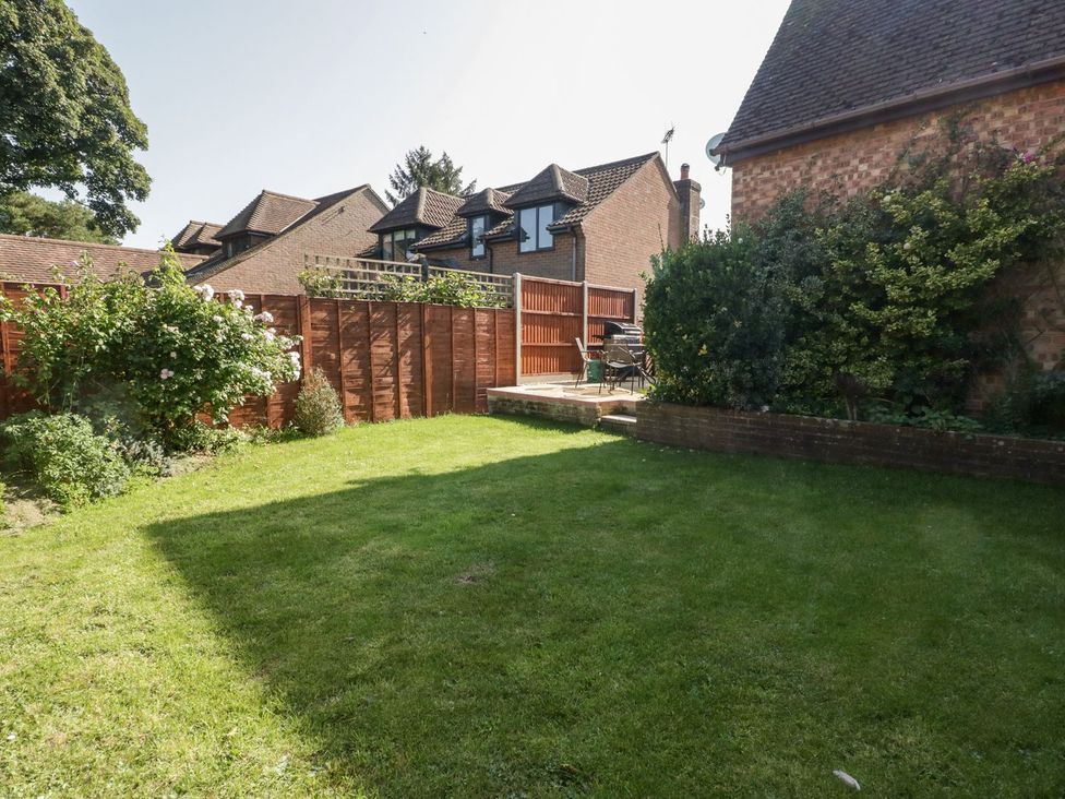 A garden with grass and patio furniture at The Cottage in Winterslow