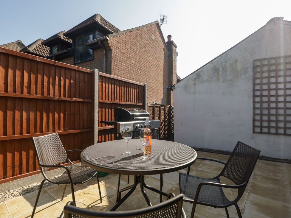 A garden with a table and chairs plus a barbecue grill at The Cottage in Winterslow