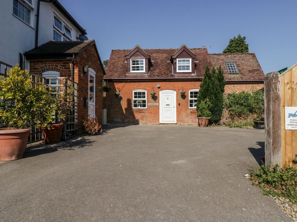 A house with a driveway and plants at The Cottage in Winterslow