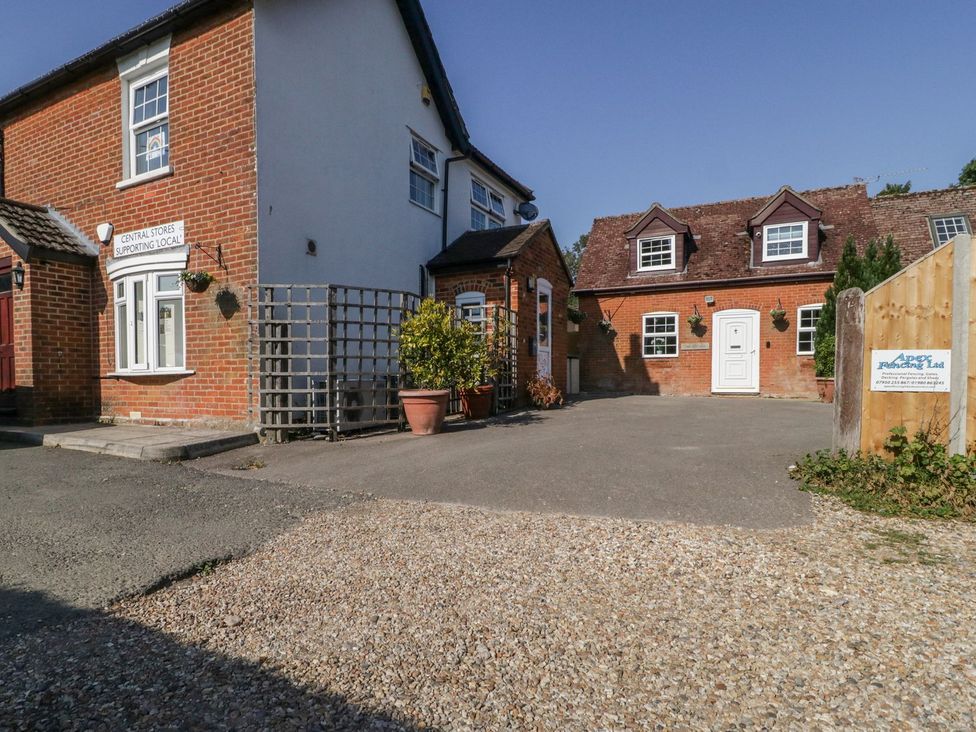 A house with a parking area and sign at The Cottage in Winterslow