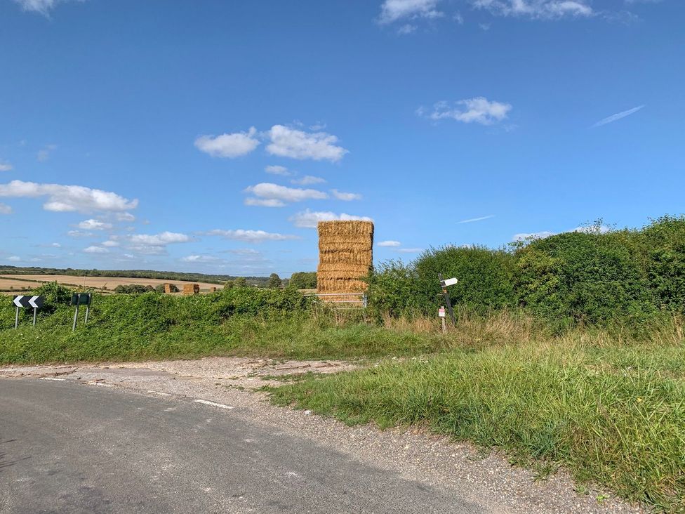 A hay bale near a road with traffic signs in a rural area at The Cottage in Winterslow