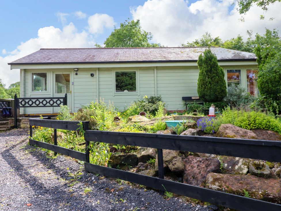 A cabin with a garden at Bull Rush Cabin Carwinley near Longtown