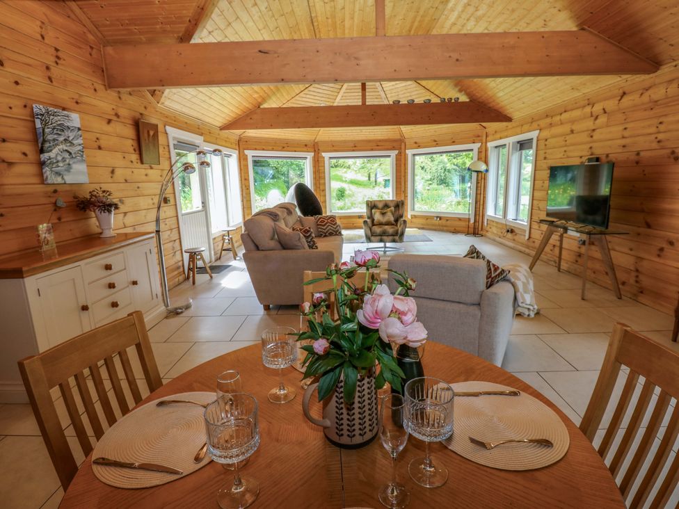 A living room with a dining table and sofa at Bull Rush Cabin in Carwinley near Longtown