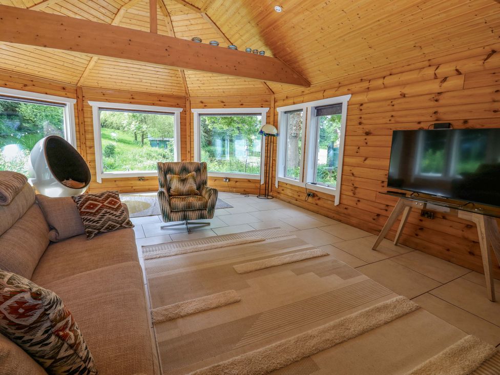 A snug with a television and seating area at Bull Rush Cabin in Carwinley near Longtown