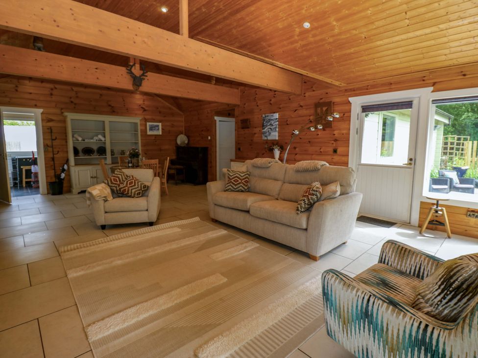 A living room with furniture including a sofa and armchairs at Bull Rush Cabin Carwinley near Longtown