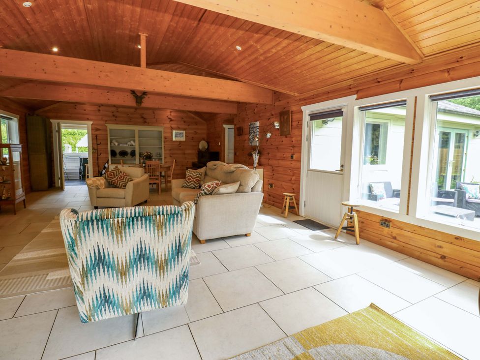 A living room with seating and tables at Bull Rush Cabin in Carwinley near Longtown