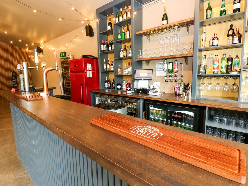 A bar with beer taps and shelves at Bull Rush Cabin Carwinley near Longtown