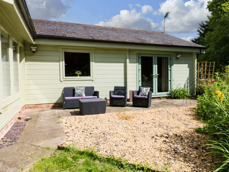 An outdoor seating area with chairs and a table at Bull Rush Cabin in Carwinley near Longtown
