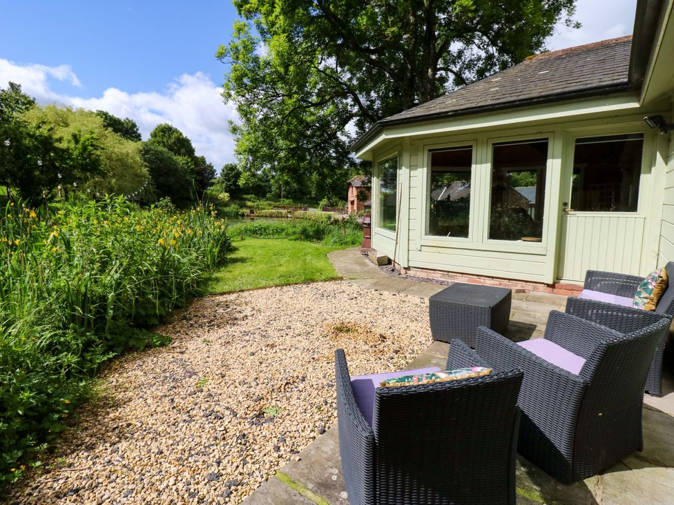 A garden area with seating and gravel at Bull Rush Cabin Carwinley near Longtown
