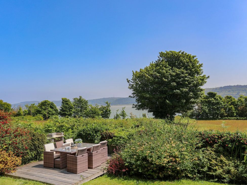 A garden with patio furniture and a view at Bryn Llifon in Pentraeth