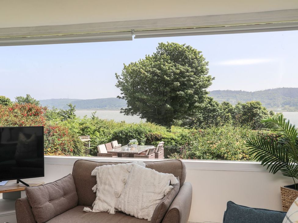 A living room with a view of outdoor furniture at Bryn Llifon in Pentraeth