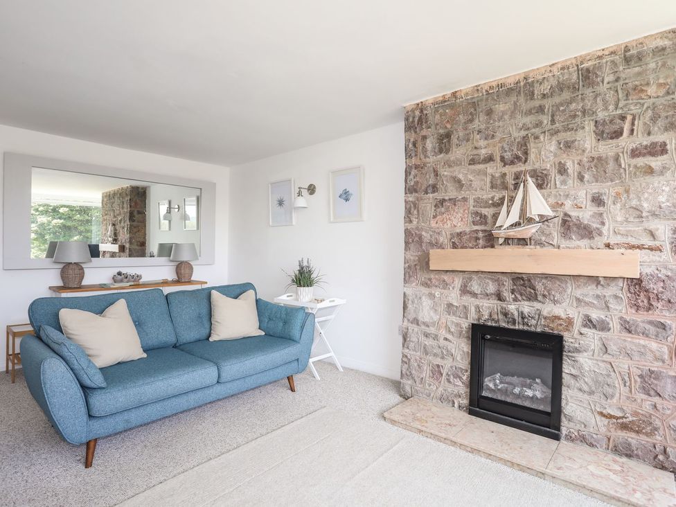 A living room with a sofa and fireplace at Bryn Llifon in Pentraeth
