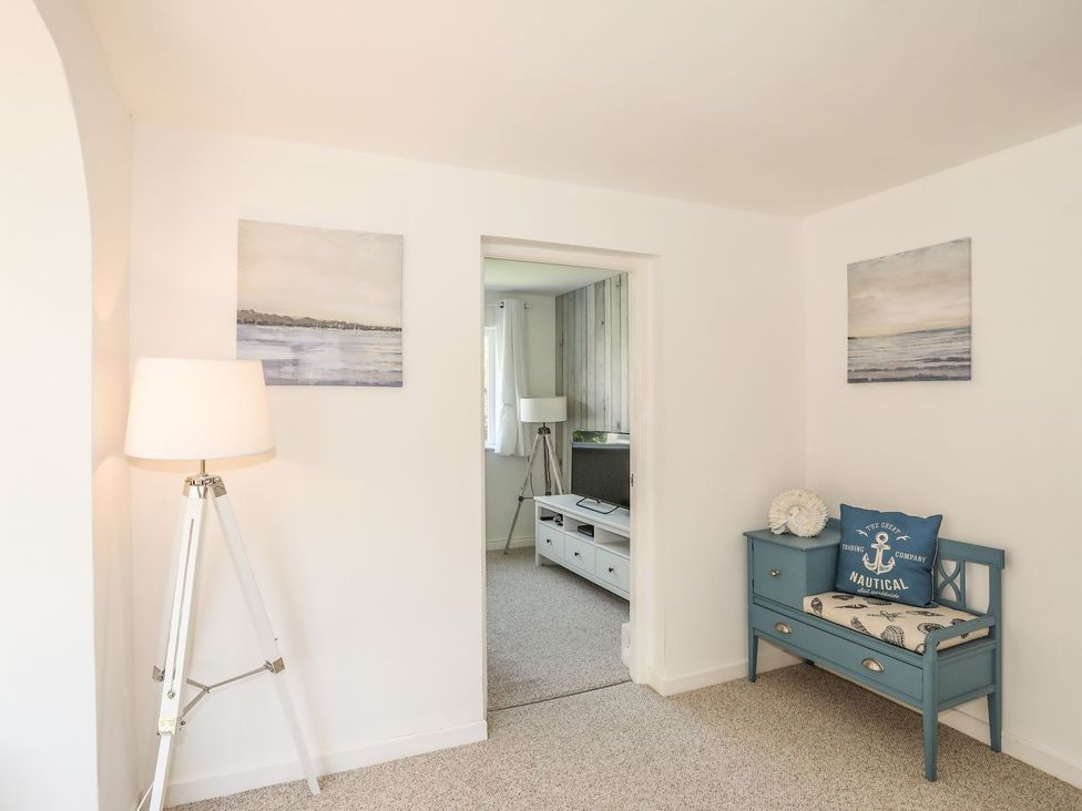 A living room with a blue bench and lamp at Bryn Llifon in Pentraeth