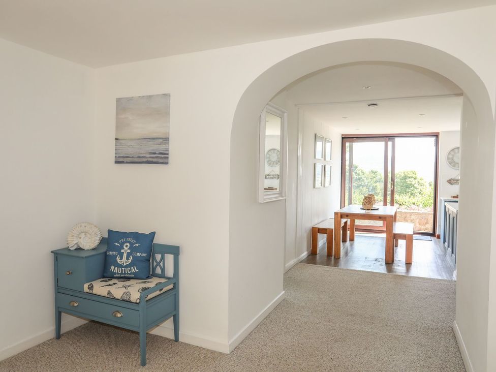 A hallway with a blue bench and dining table at Bryn Llifon in Pentraeth