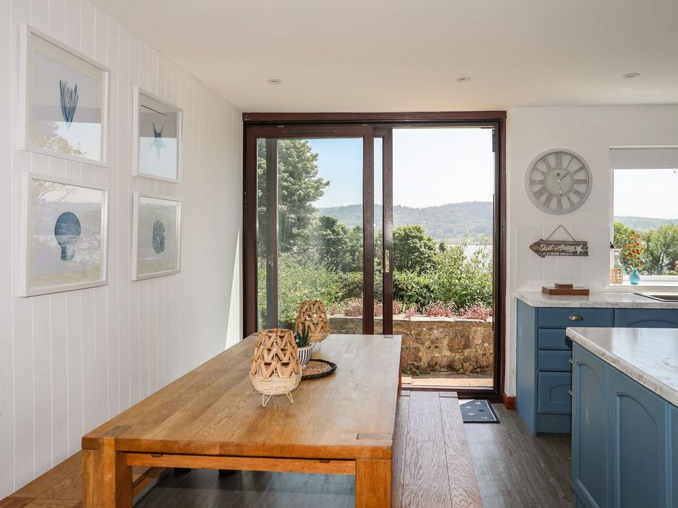 A dining room with a table and artwork at Bryn Llifon in Pentraeth