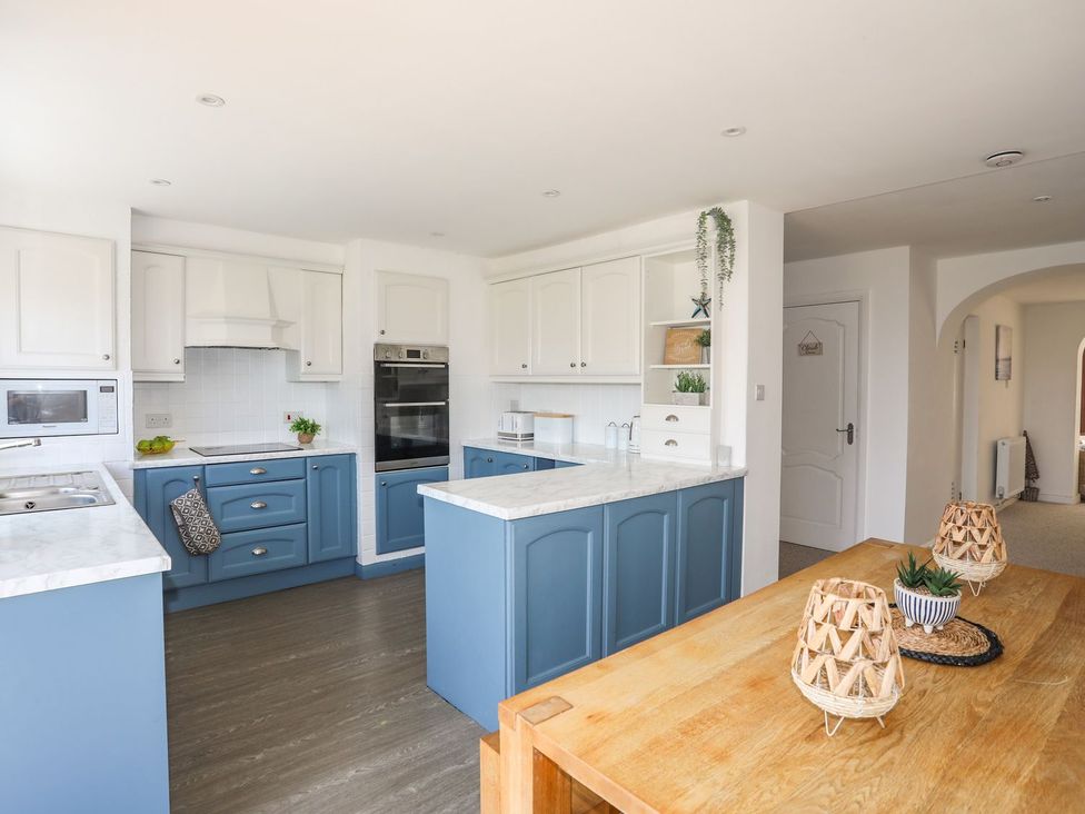 A kitchen with cabinets and appliances at Bryn Llifon in Pentraeth