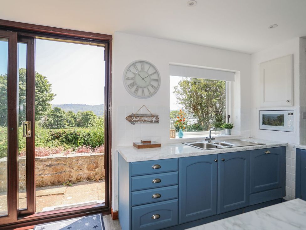 A kitchen with a sink and microwave at Bryn Llifon in Pentraeth