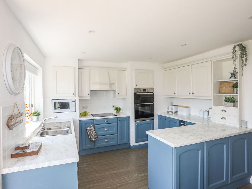 A kitchen with blue cabinets and a countertop at Bryn Llifon in Pentraeth