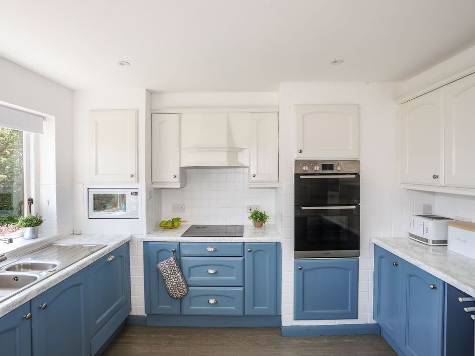 A kitchen with cabinets and appliances at Bryn Llifon in Pentraeth