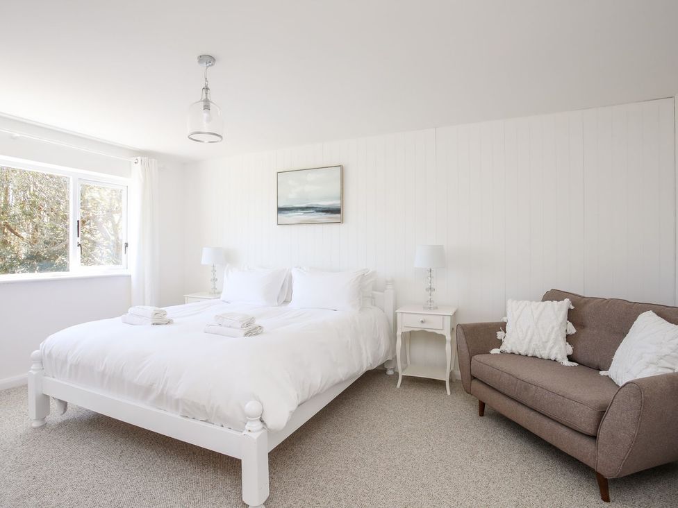 A bedroom with a bed and a sofa at Bryn Llifon in Pentraeth