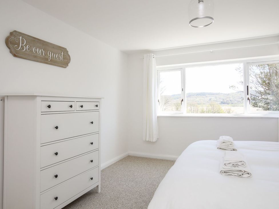 A bedroom with a dresser and bed at Bryn Llifon in Pentraeth