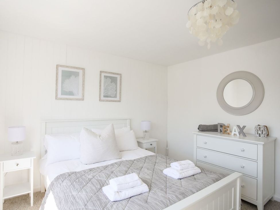A bedroom with a bed and dresser at Bryn Llifon in Pentraeth