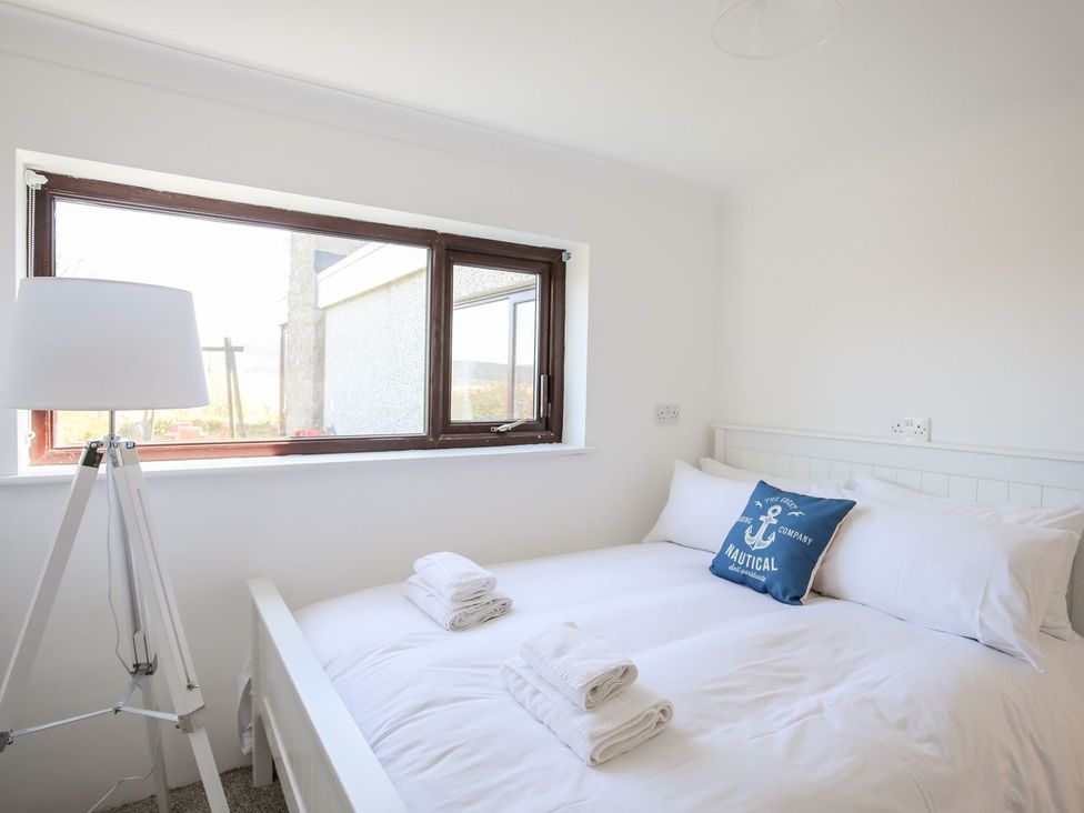A bedroom with a bed and lamp at Bryn Llifon in Pentraeth