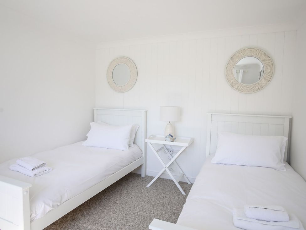 A bedroom with two beds and a table at Bryn Llifon in Pentraeth