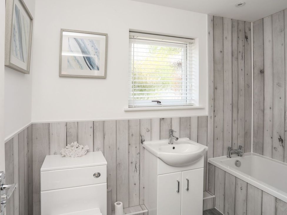 A bathroom with a sink, toilet and bathtub at Bryn Llifon in Pentraeth