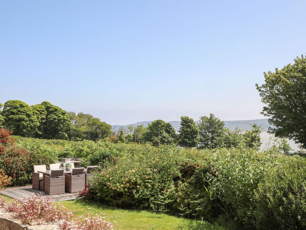 A garden with patio furniture and trees at Bryn Llifon in Pentraeth