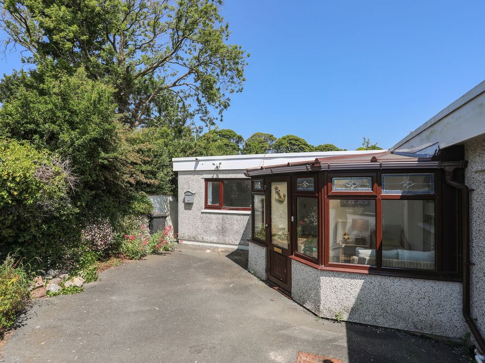 An outdoor view of a conservatory and garden area at Bryn Llifon in Pentraeth