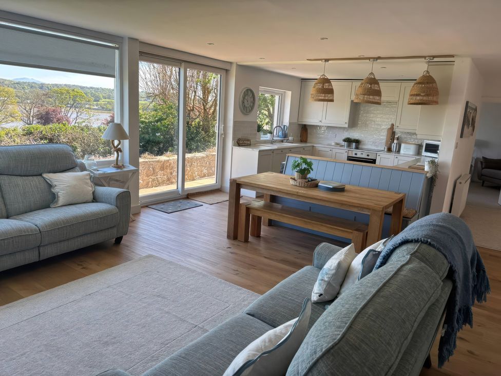 A living room with a sofa and dining table at Red Wharf Retreat Red Wharf Bay near Benllech
