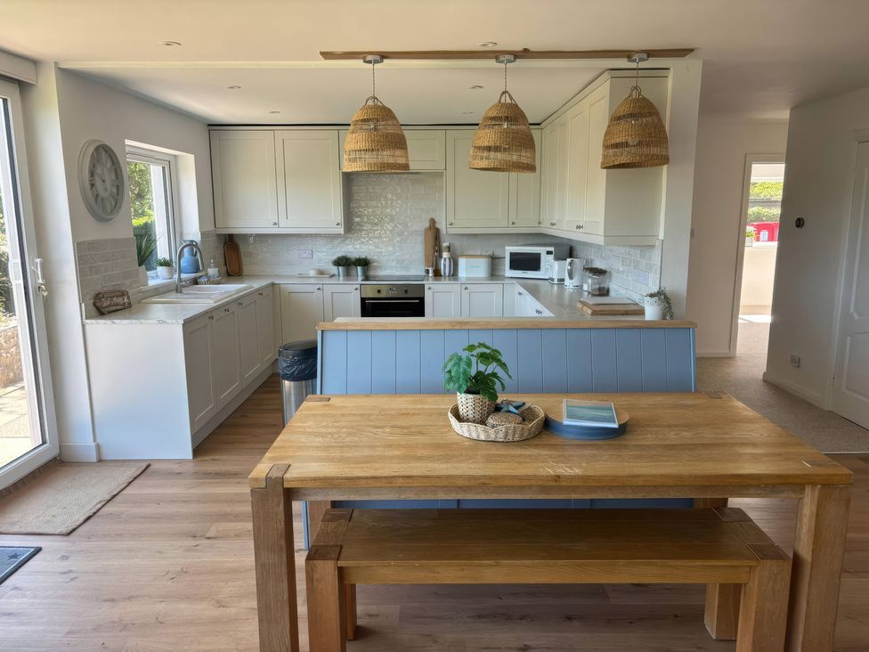 A kitchen with a wooden table and chairs at Red Wharf Retreat Red Wharf Bay near Benllech