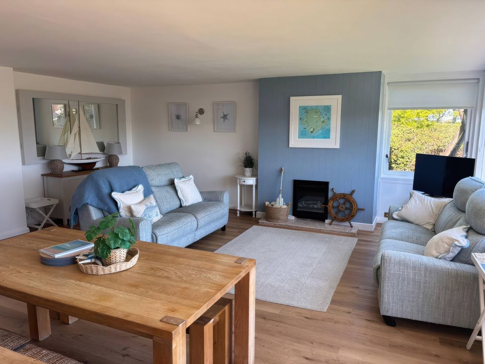 A living room with sofas and a table at Red Wharf Retreat near Red Wharf Bay