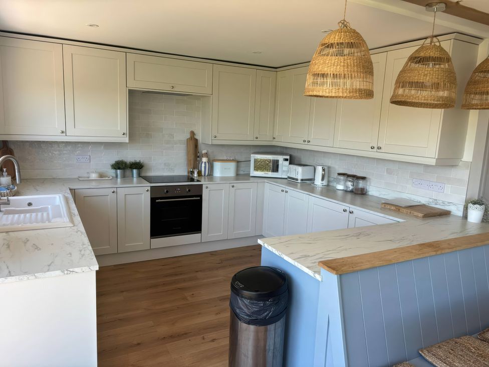 A kitchen featuring cabinetry, appliances, and a sink at Red Wharf Retreat in Red Wharf Bay near Benllech