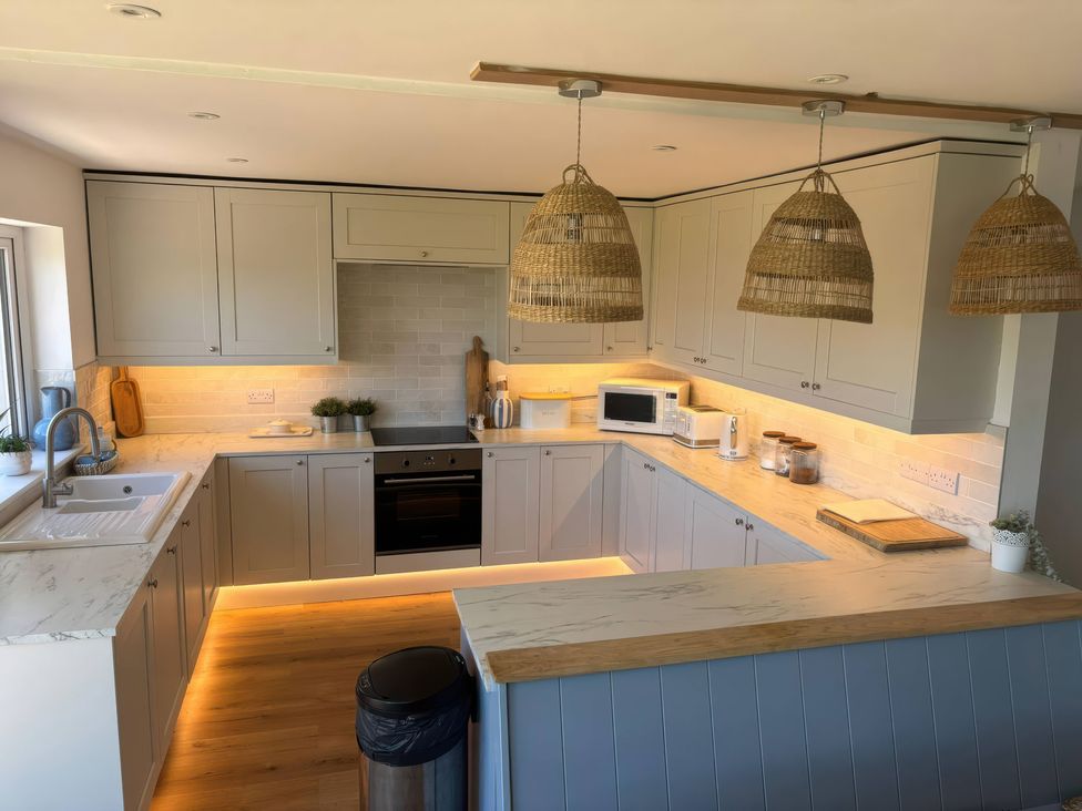 A kitchen with cabinets and countertop at Red Wharf Retreat near Red Wharf Bay