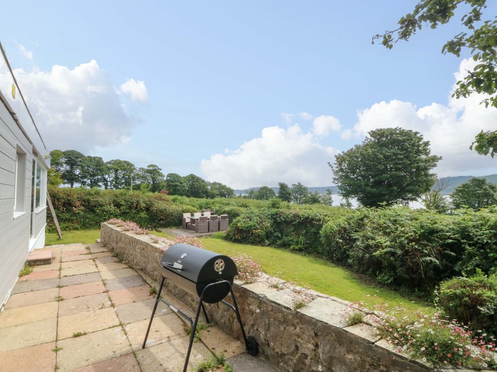 A garden with a barbecue and outdoor seating at Red Wharf Retreat near Red Wharf Bay