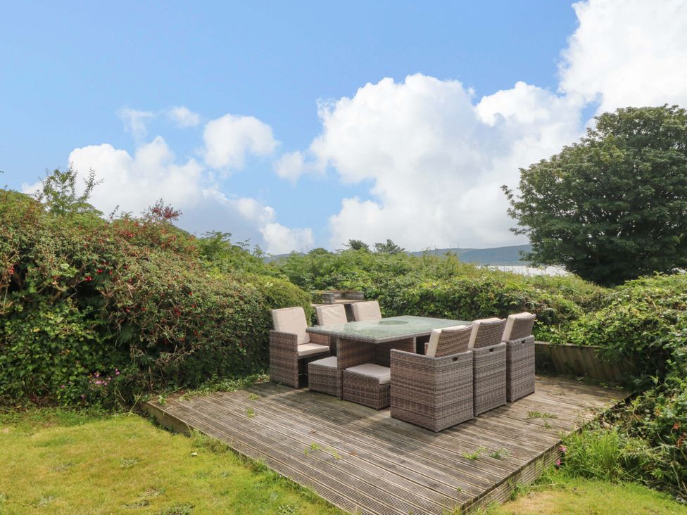 An outdoor seating area with a table and chairs at Red Wharf Retreat near Red Wharf Bay