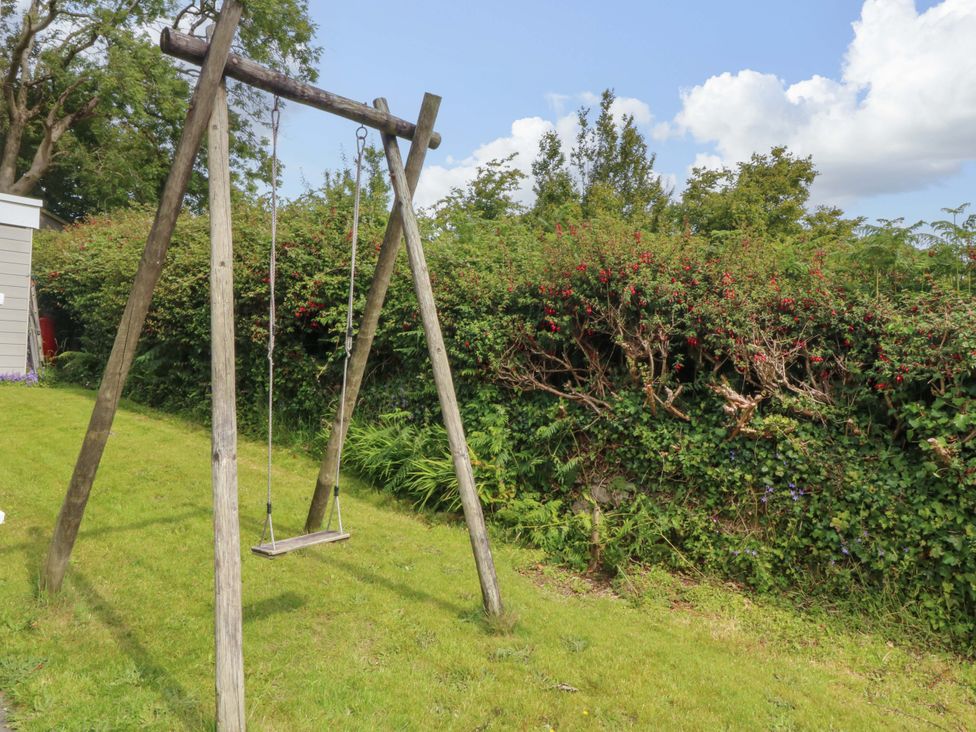 A swing set in the garden at Red Wharf Retreat near Benllech