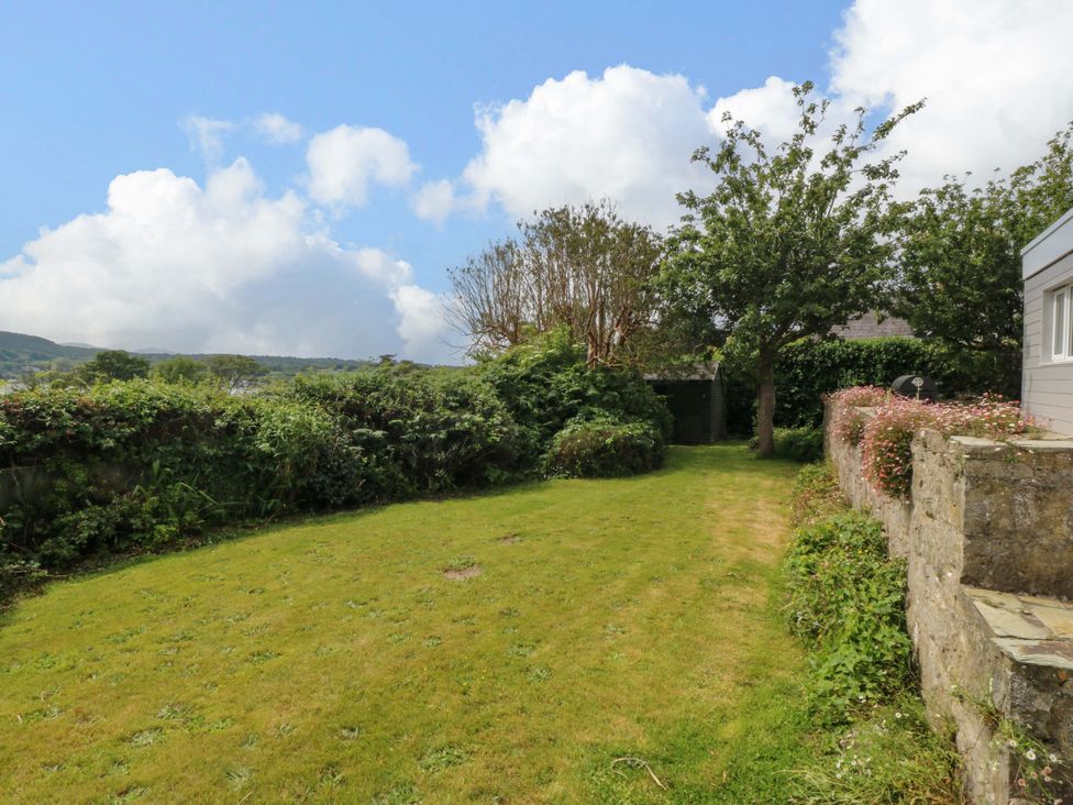 A garden with grass and trees at Red Wharf Retreat near Red Wharf Bay