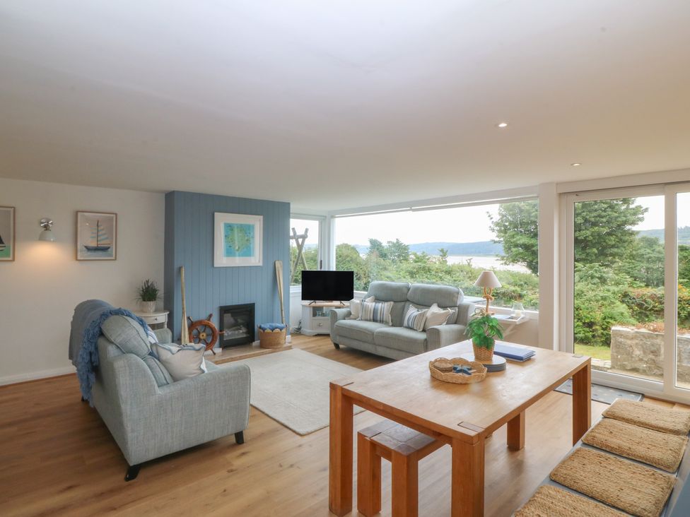 A living room with a sofa and dining table at Red Wharf Retreat near Red Wharf Bay
