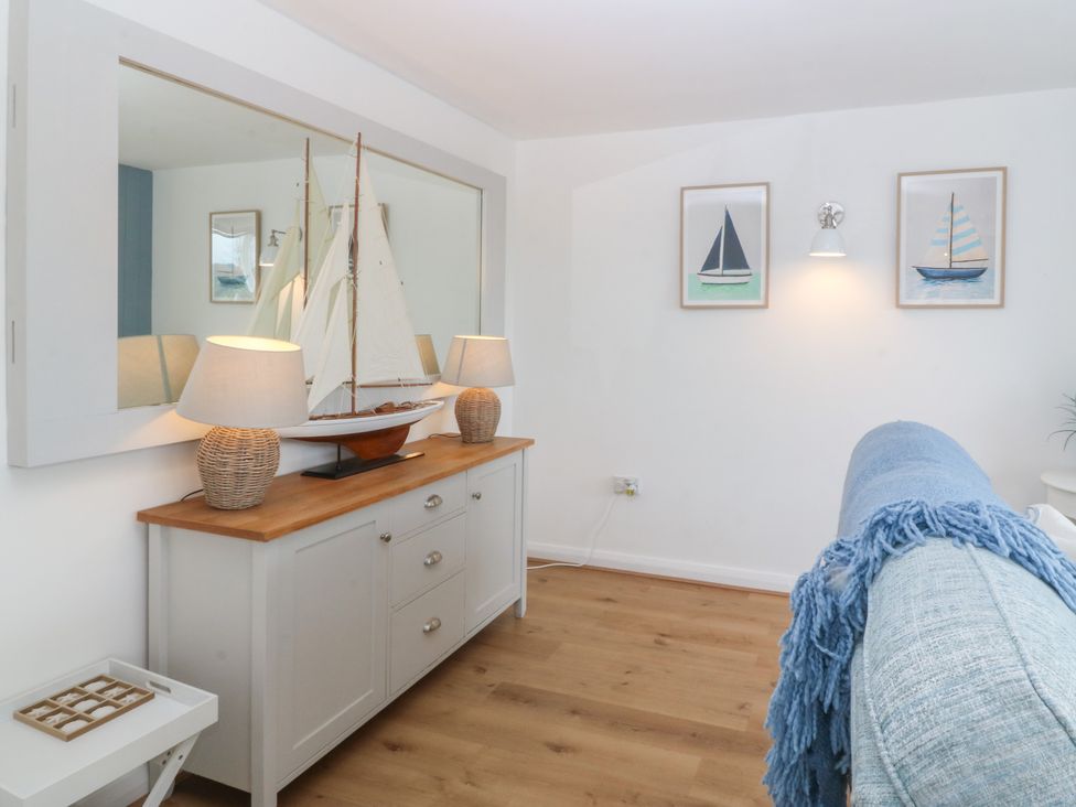 A living room with a sailboat on a table at Red Wharf Retreat Red Wharf Bay near Benllech