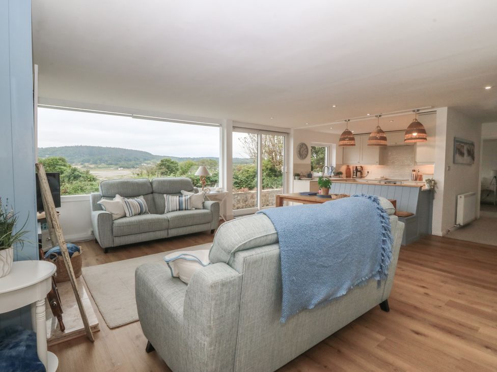A living room with a sofa and dining area at Red Wharf Retreat in Red Wharf Bay near Benllech