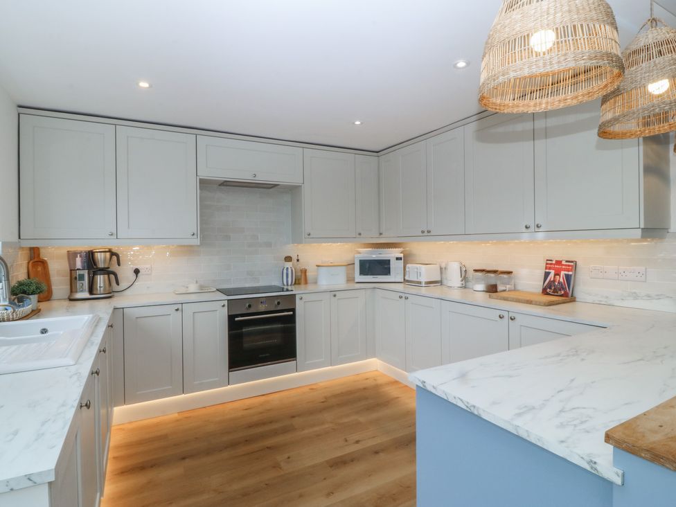 A kitchen with modern appliances and cabinetry at Red Wharf Retreat in Red Wharf Bay near Benllech