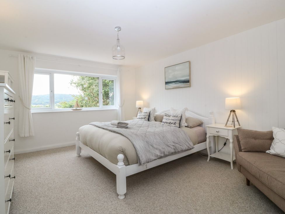 A bedroom with a bed and nightstand at Red Wharf Retreat in Red Wharf Bay near Benllech