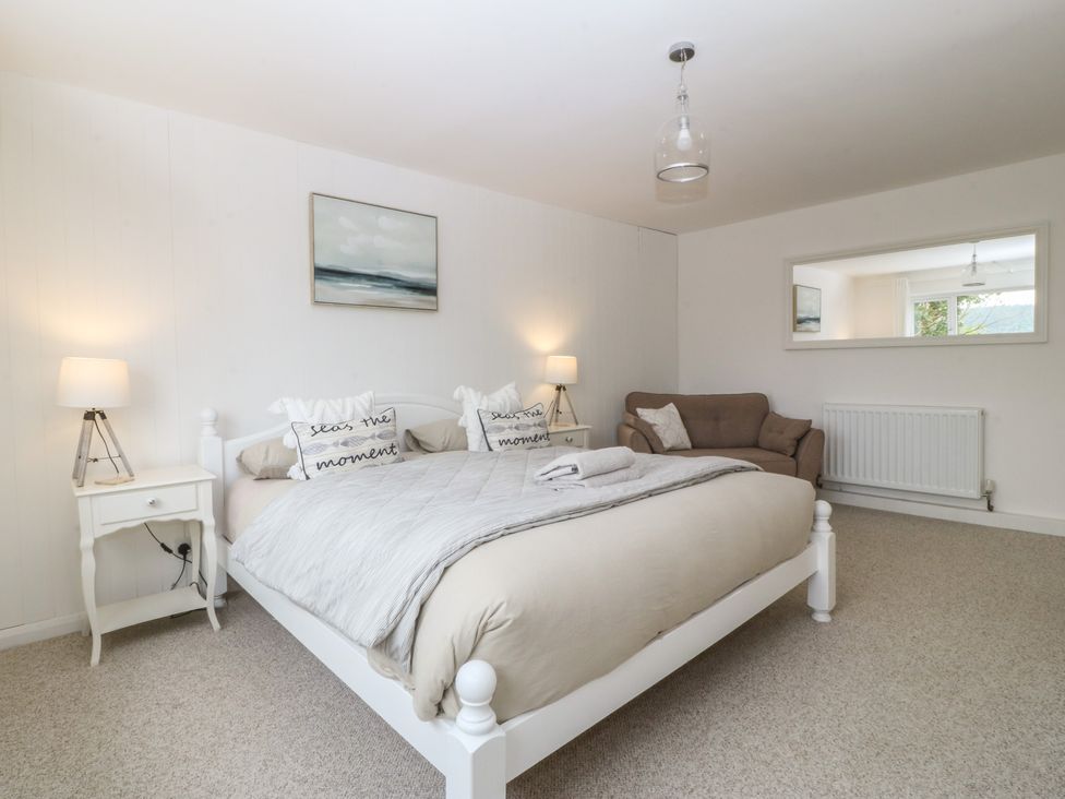 A bedroom with a bed and nightstand at Red Wharf Retreat in Red Wharf Bay near Benllech