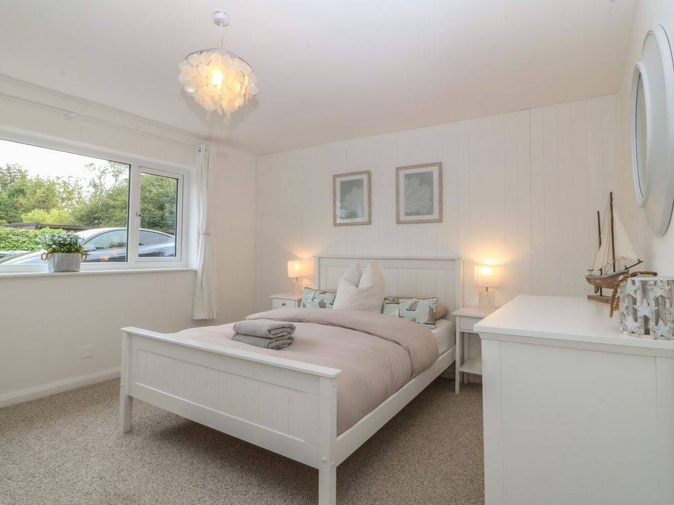 A bedroom with a bed and window at Red Wharf Retreat in Red Wharf Bay near Benllech