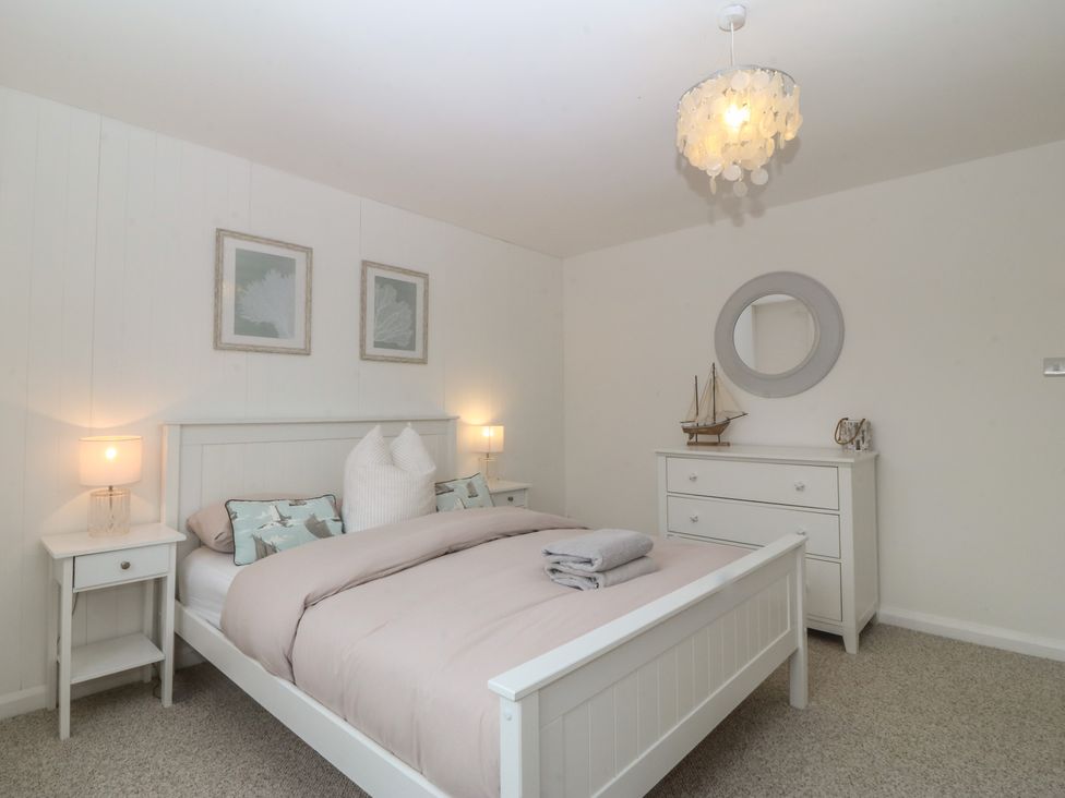 A bedroom with a bed and bedside tables at Red Wharf Retreat near Red Wharf Bay