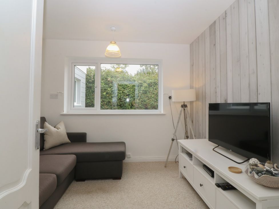 A living room with a sofa and television at Red Wharf Retreat near Red Wharf Bay