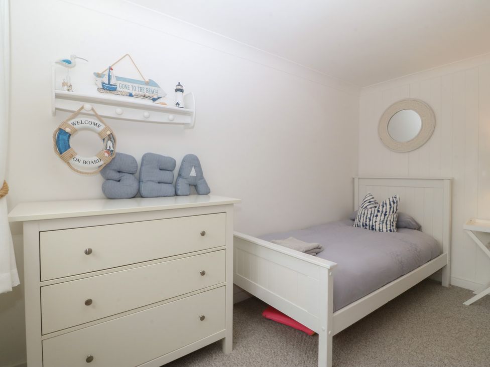 A bedroom with a bed and dresser at Red Wharf Retreat Red Wharf Bay near Benllech